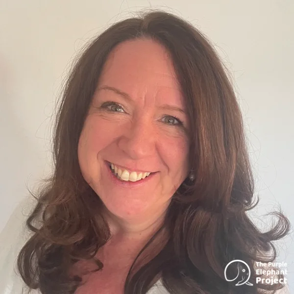 Jenny Haylock, a smiling woman with long brown hair wearing a white top, standing against a plain light background. The Purple Elephant Project logo is in the bottom right-hand corner.